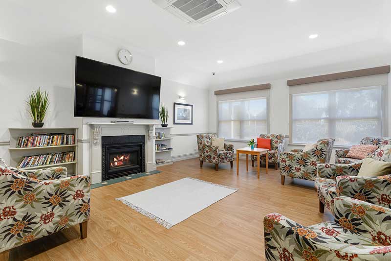 Doutta Galla Yarraville - living room with fireplace, comfortable chairs and large mounted television