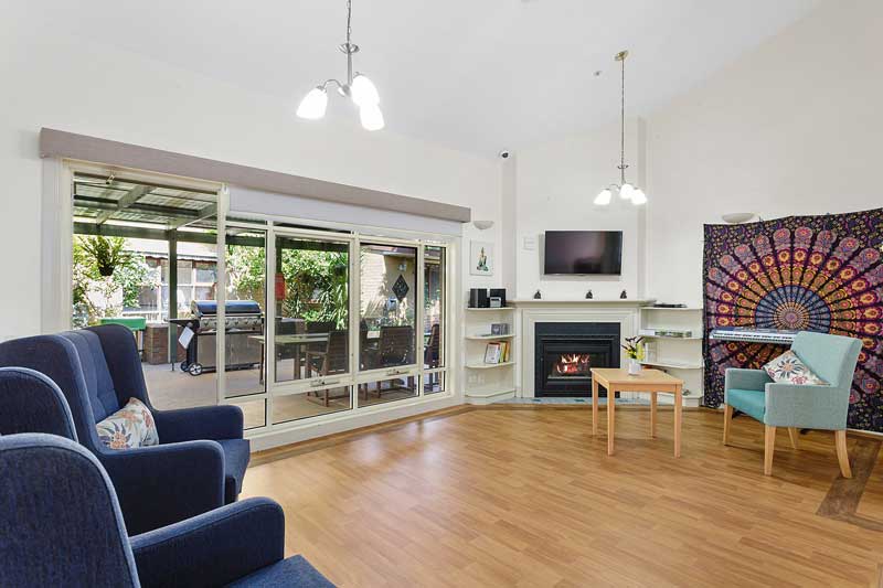 Doutta Galla Yarraville - living room with fireplace and doorway to outside barbecue area